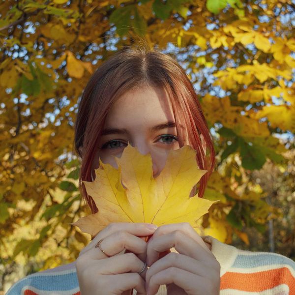Smiling person stretching outdoors in a park during sunrise.